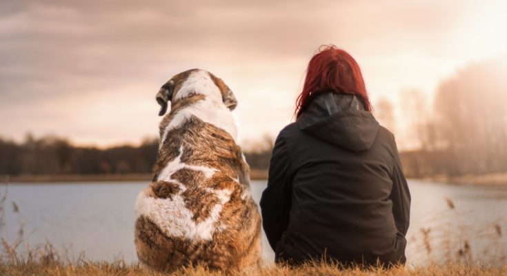 a girl sitting with her dog